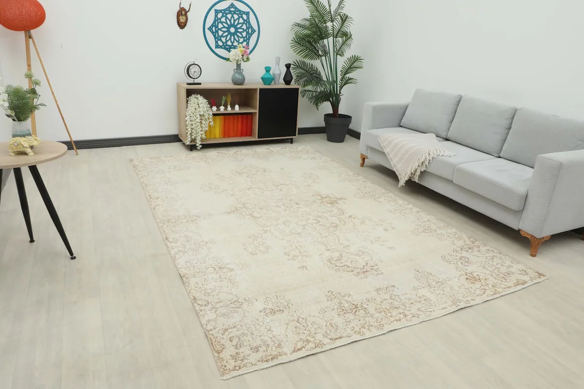 Large ivory and tan vintage rug placed in a modern living room setting