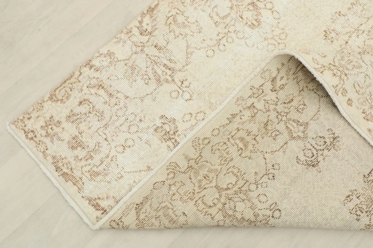 View of the rug folded back to reveal the cotton foundation and reverse side