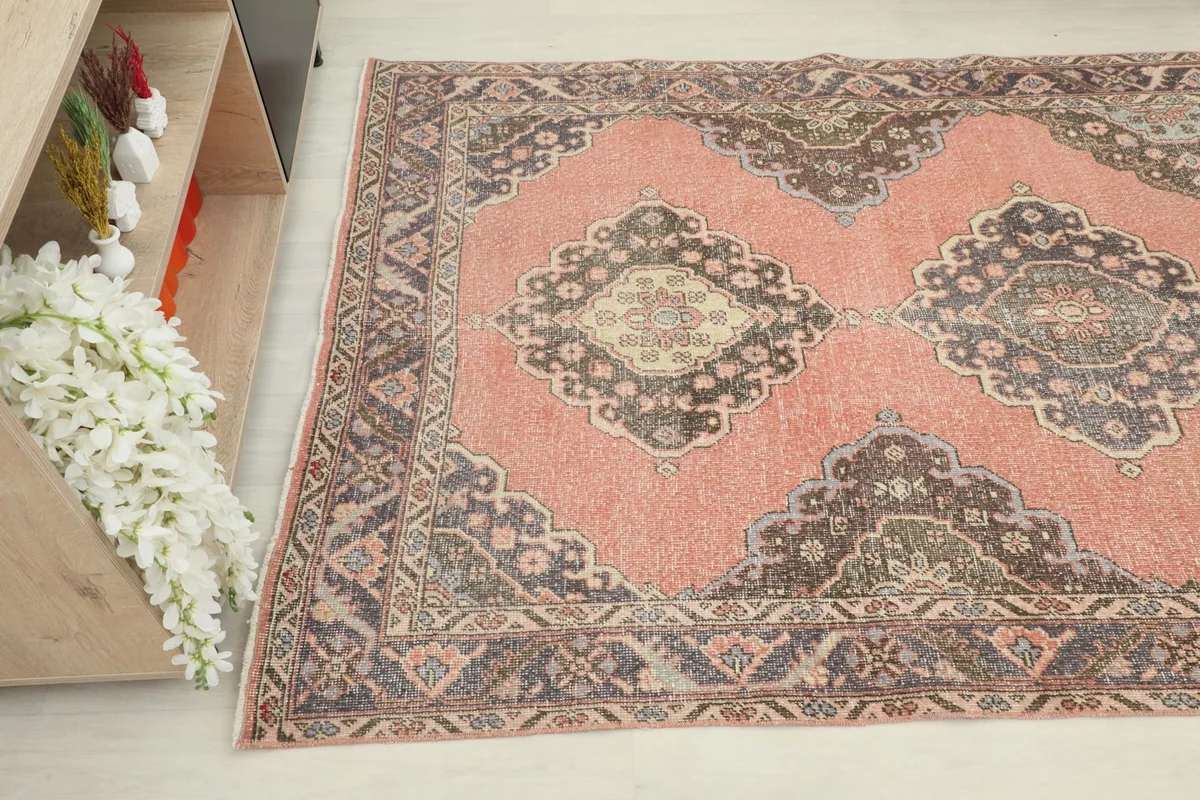 Angled view of the runner rug showing the rose field and charcoal medallion designs