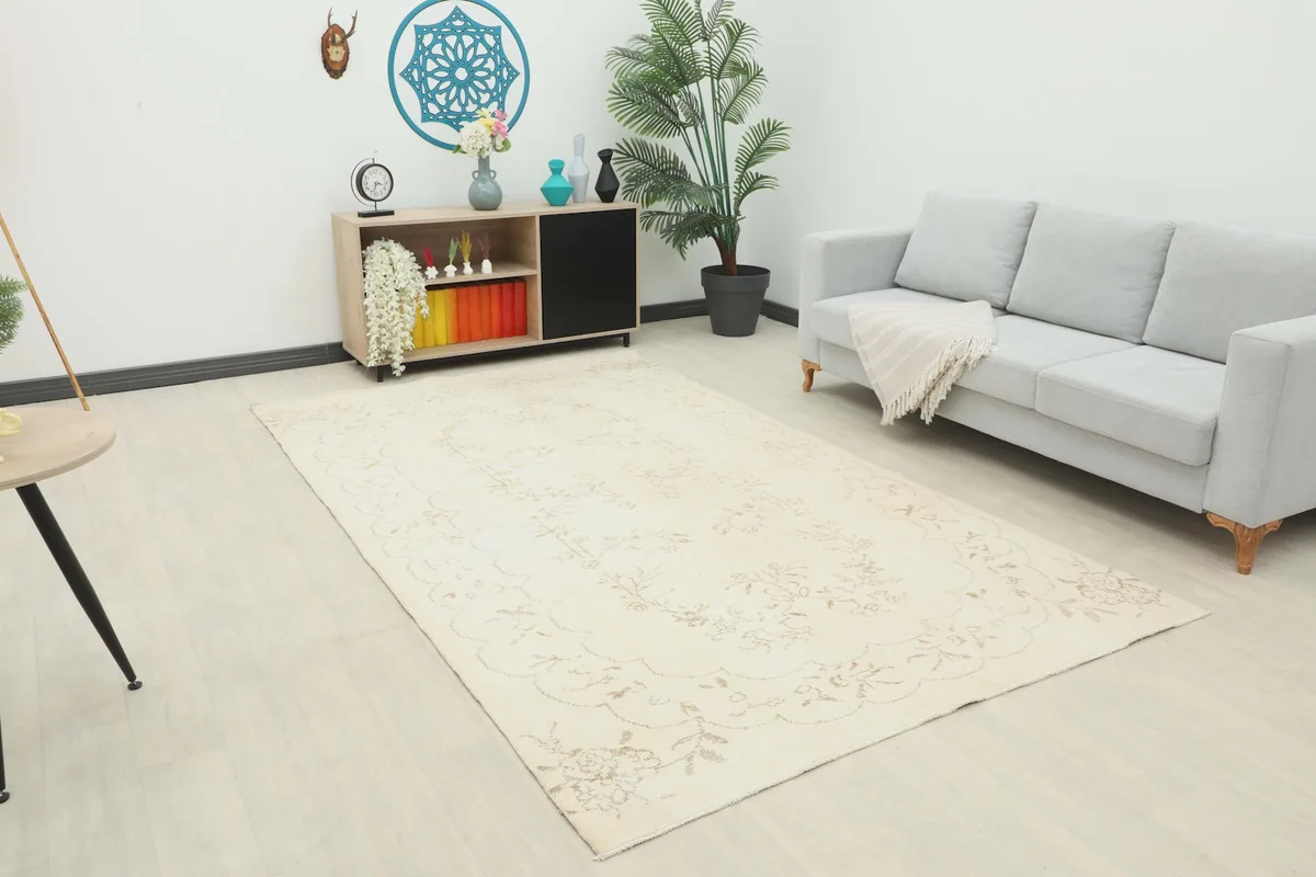 Ivory floral vintage rug displayed in a bright living room setup with a gray sofa and wooden furniture