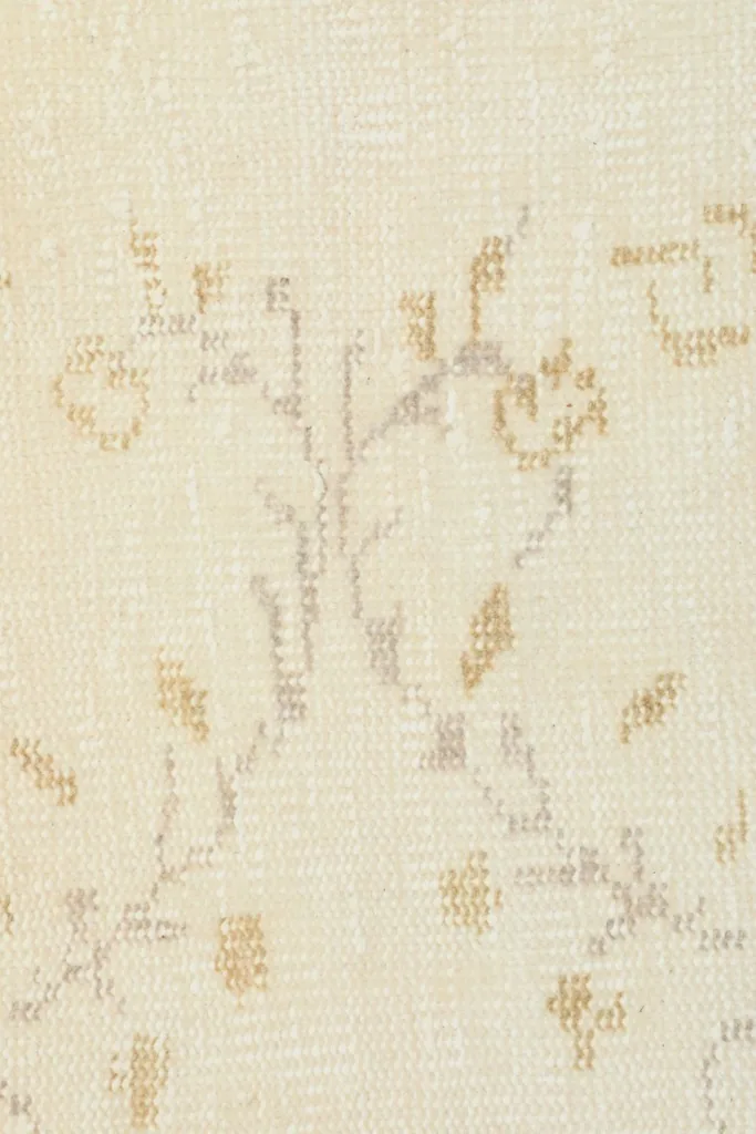 Extreme close-up showing the hand-knotted wool pile and intricate details of the floral design