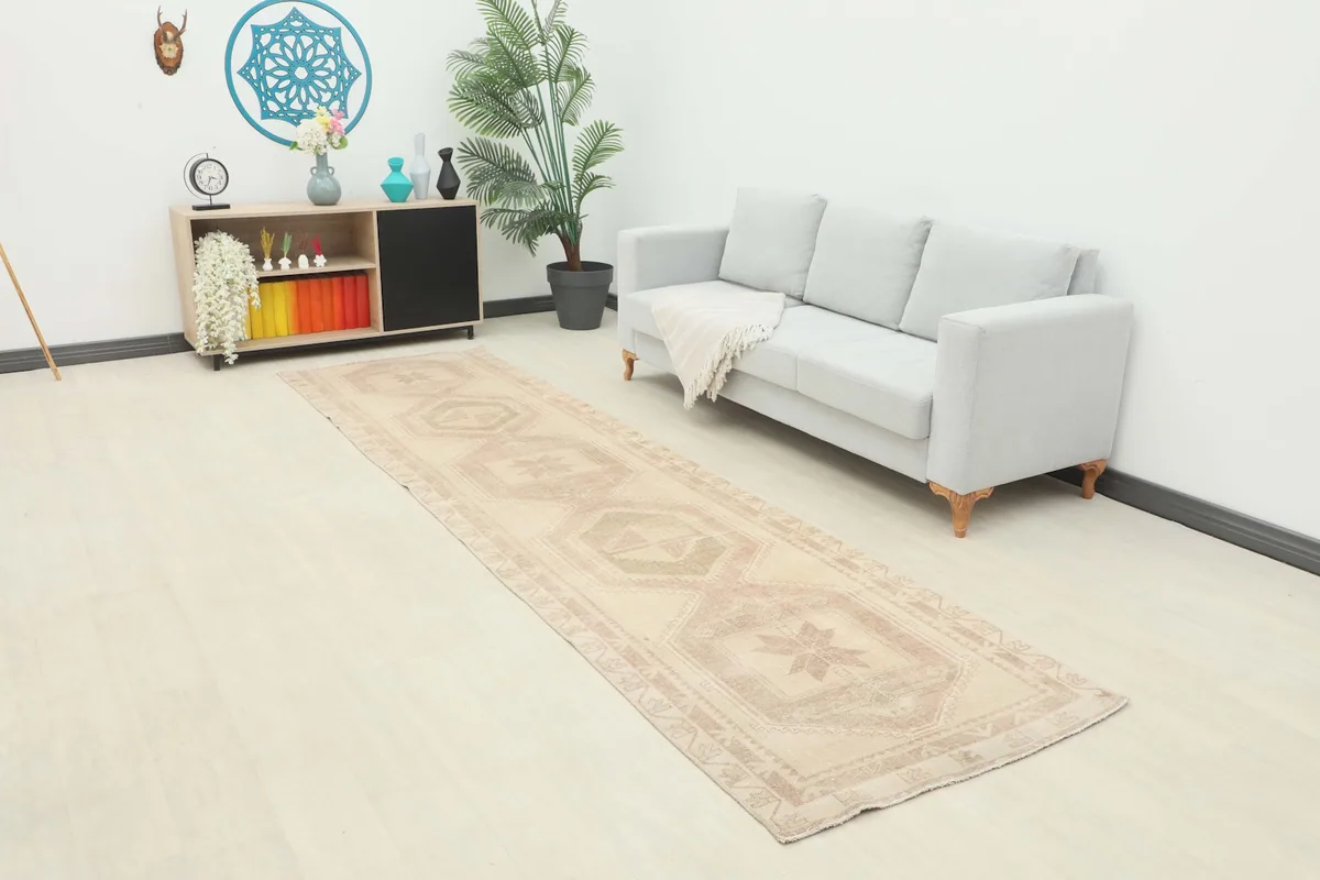 Vintage Anatolian runner rug displayed in a living room setting with a light-colored sofa and minimalist decor.