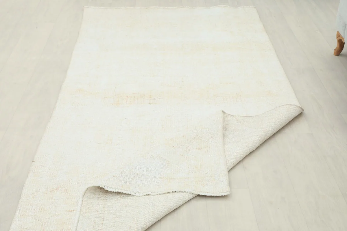 View of the rug's underside, revealing the tightly woven cotton foundation and the back of the wool knots.