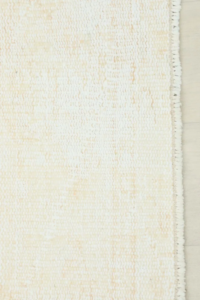 Detail of the rug's short, natural fringes and the edge of the hand-knotted cotton foundation.