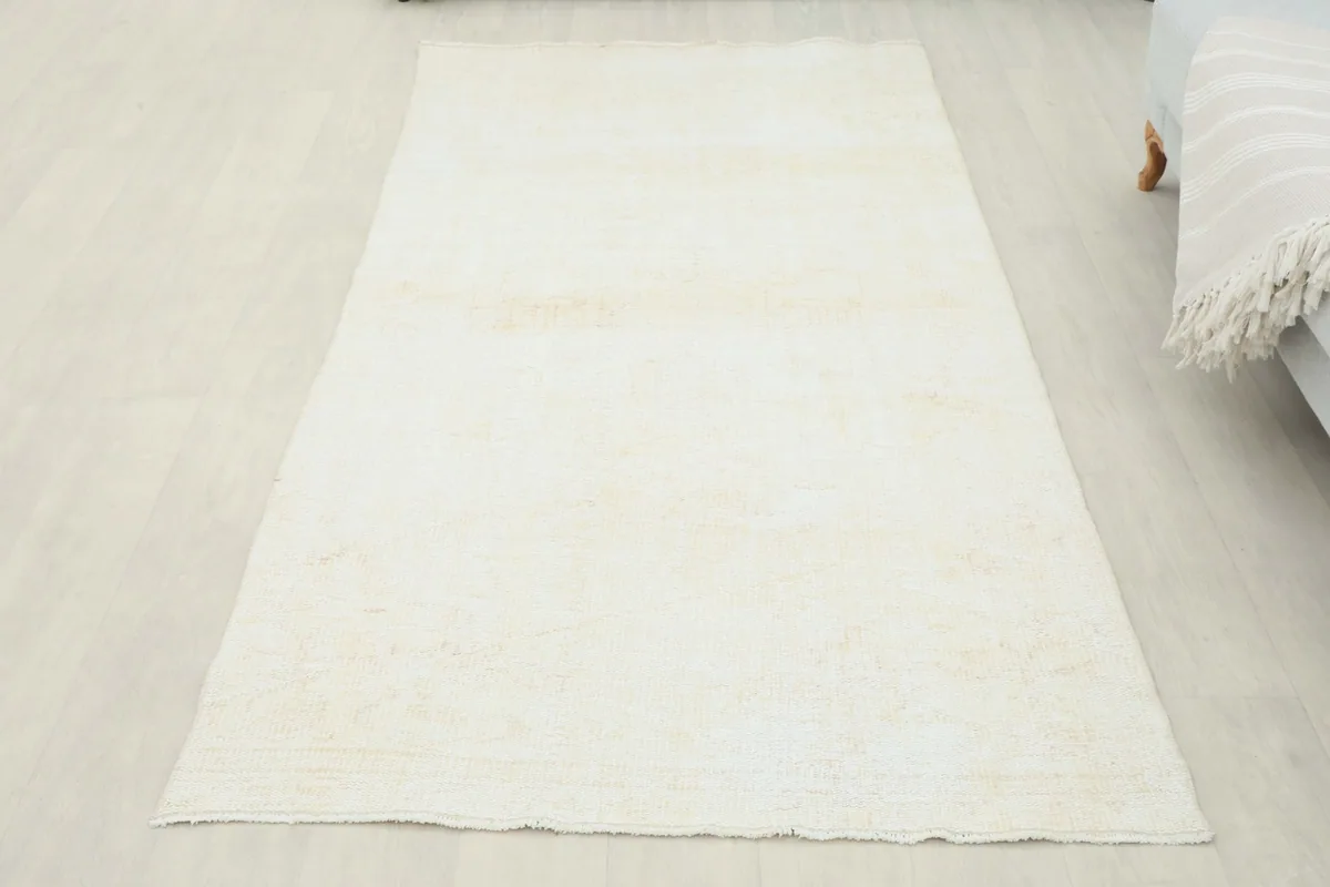 Full overhead view of the cream vintage Anatolian runner laid out on a light-colored floor.