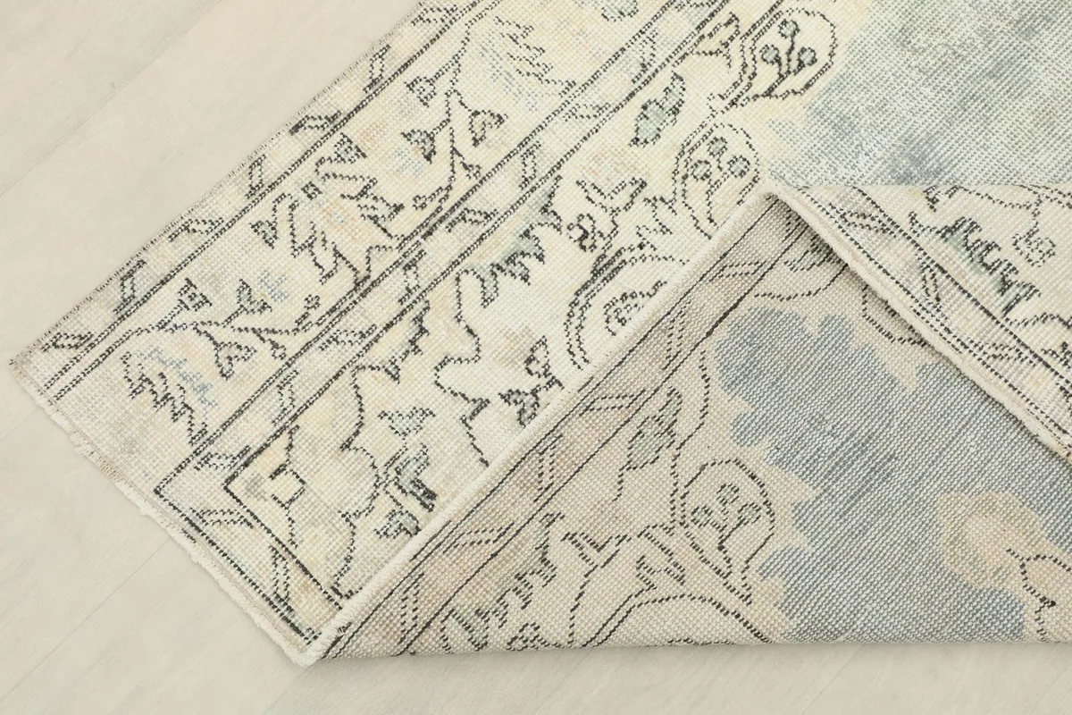 View of the rug folded to show the wool pile and cotton foundation construction