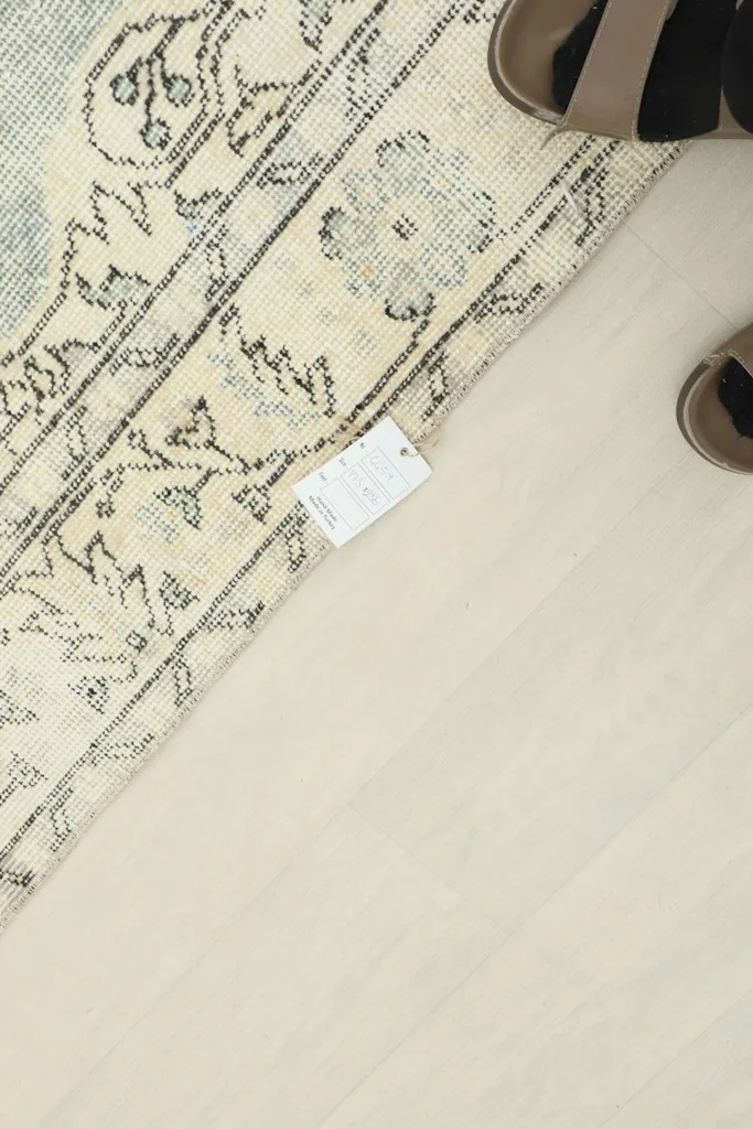 Corner of the rug with a tag, showing the texture of the wool pile and fringe