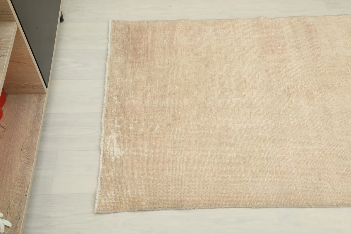 Detail view of the tan runner's surface, highlighting its vintage texture and low pile.