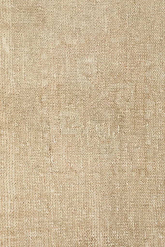 Close-up of the low wool pile, revealing the hand-knotted texture and soft tan color.