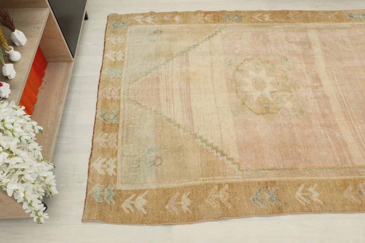 Angled view looking down the runner, highlighting the faded rose tones and tan border