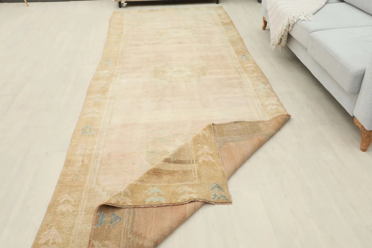 Runner rug partially folded, revealing its thickness and the reverse side