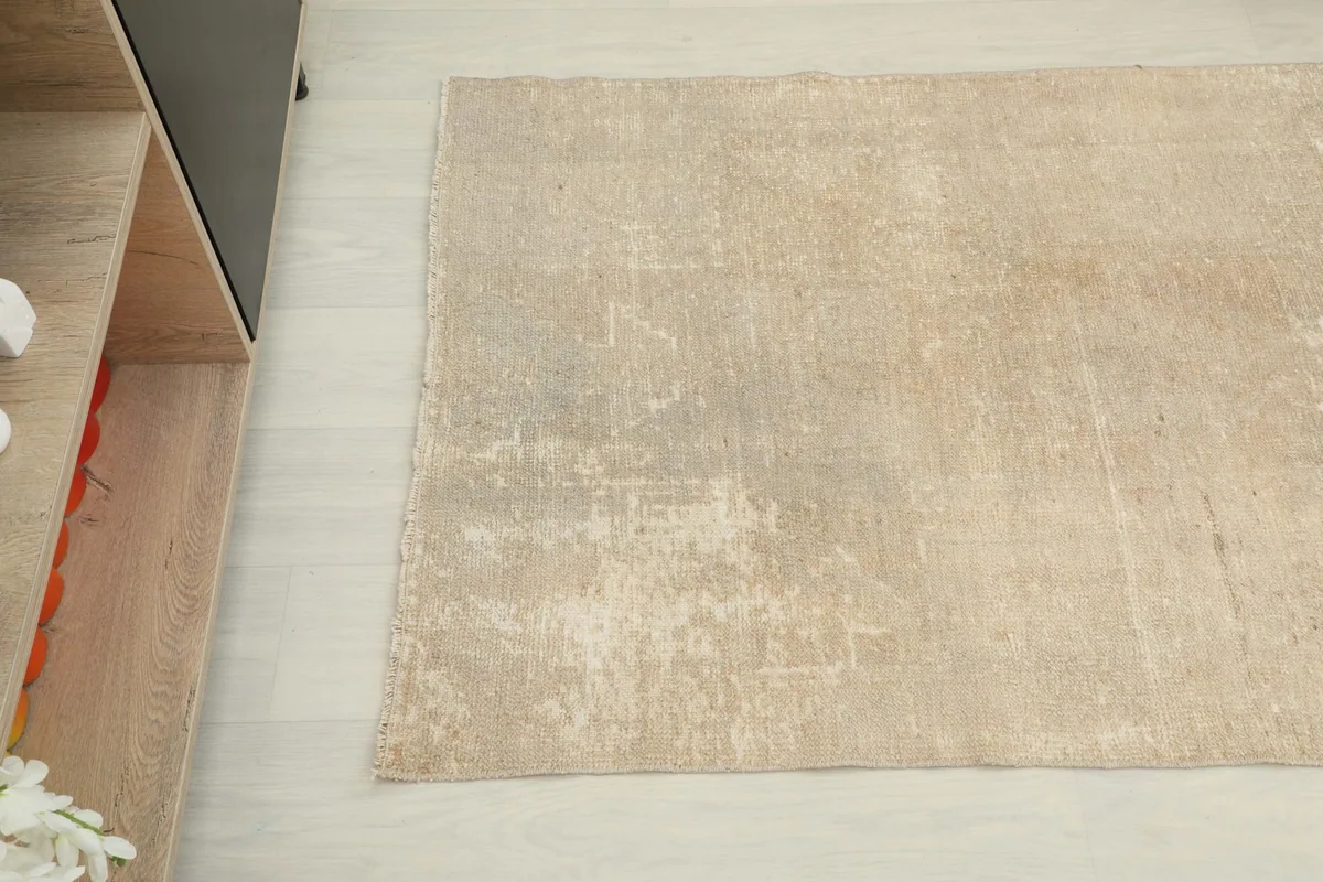Overhead detail of the beige runner rug, highlighting its muted colors and distressed texture