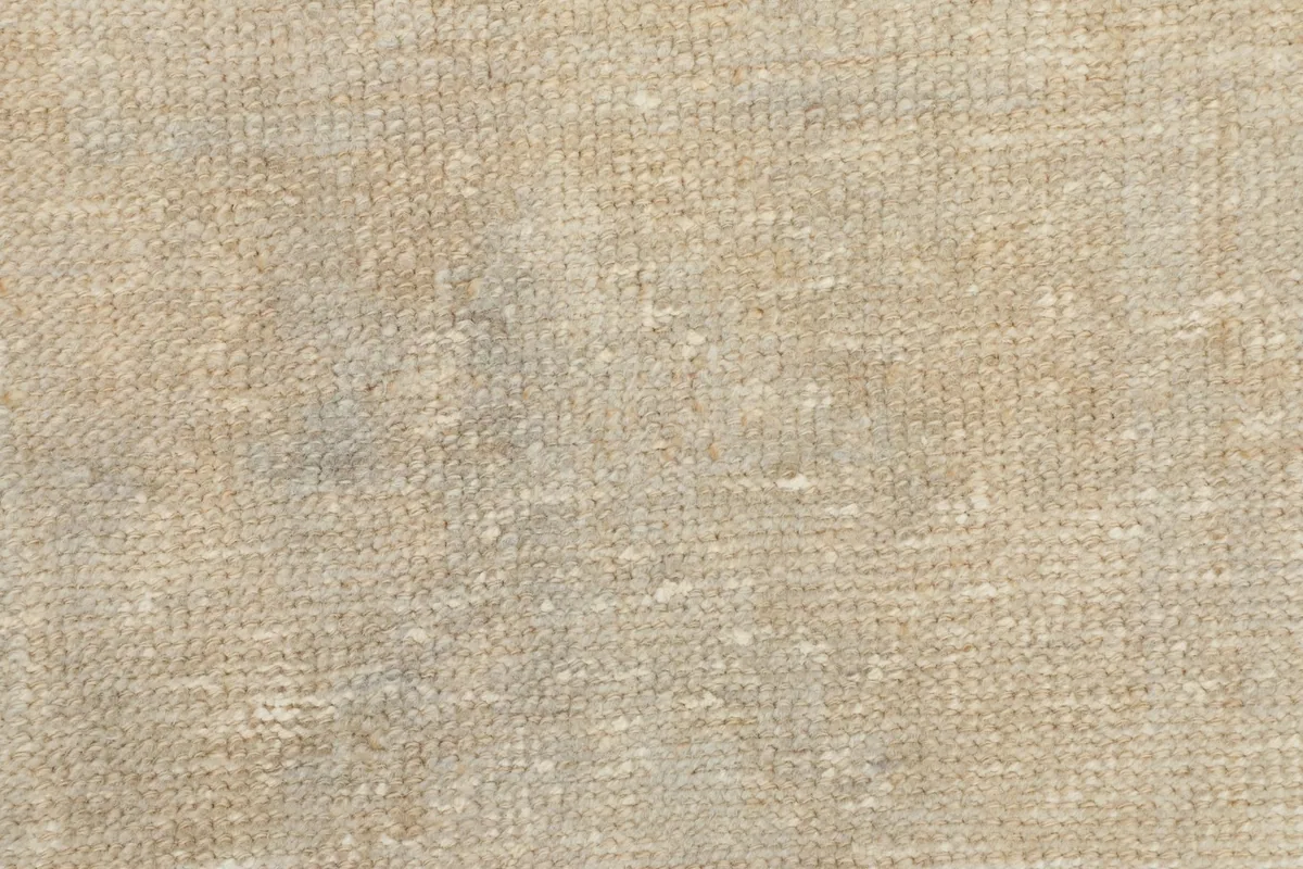 Detailed shot of the low wool pile and hand-knotted texture of the beige runner rug