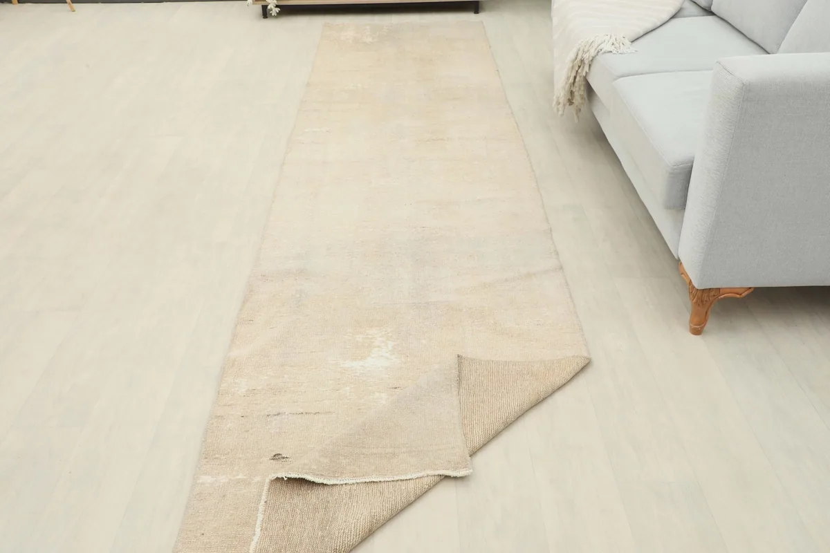Runner rug with one end folded back, showcasing the thickness and flexibility of the vintage wool