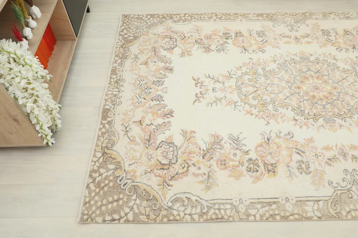 Detail of the rug's corner and border design, highlighting the beige and gray tones in the pattern.