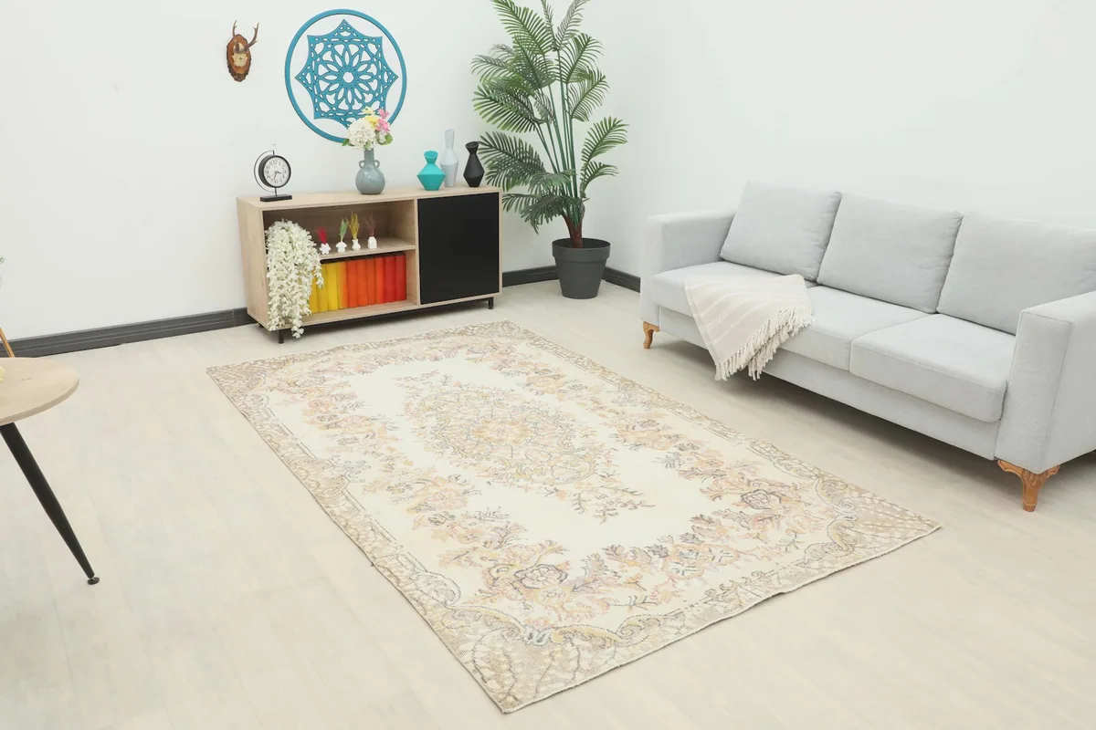 Vintage Anatolian rug displayed in a bright living room setting with a light gray sofa and modern furniture.