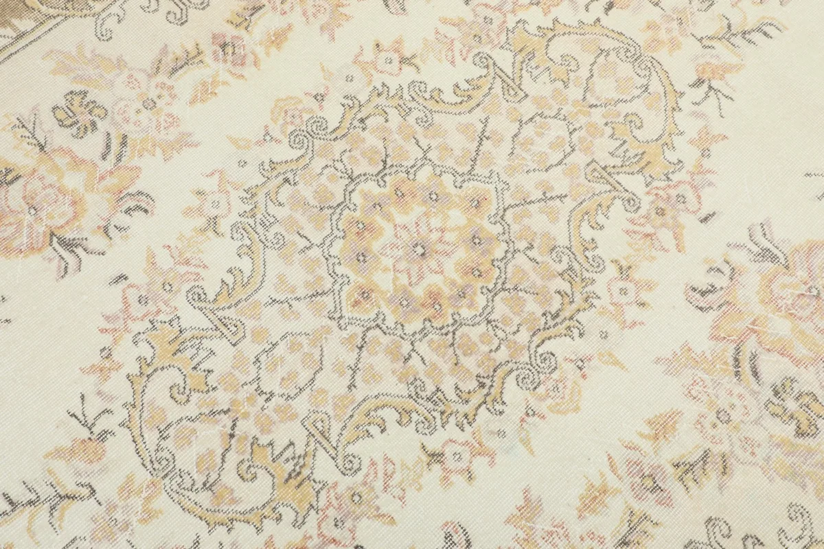 Close-up of the central medallion, revealing the subtle rust, beige, and gray colors in the wool pile.