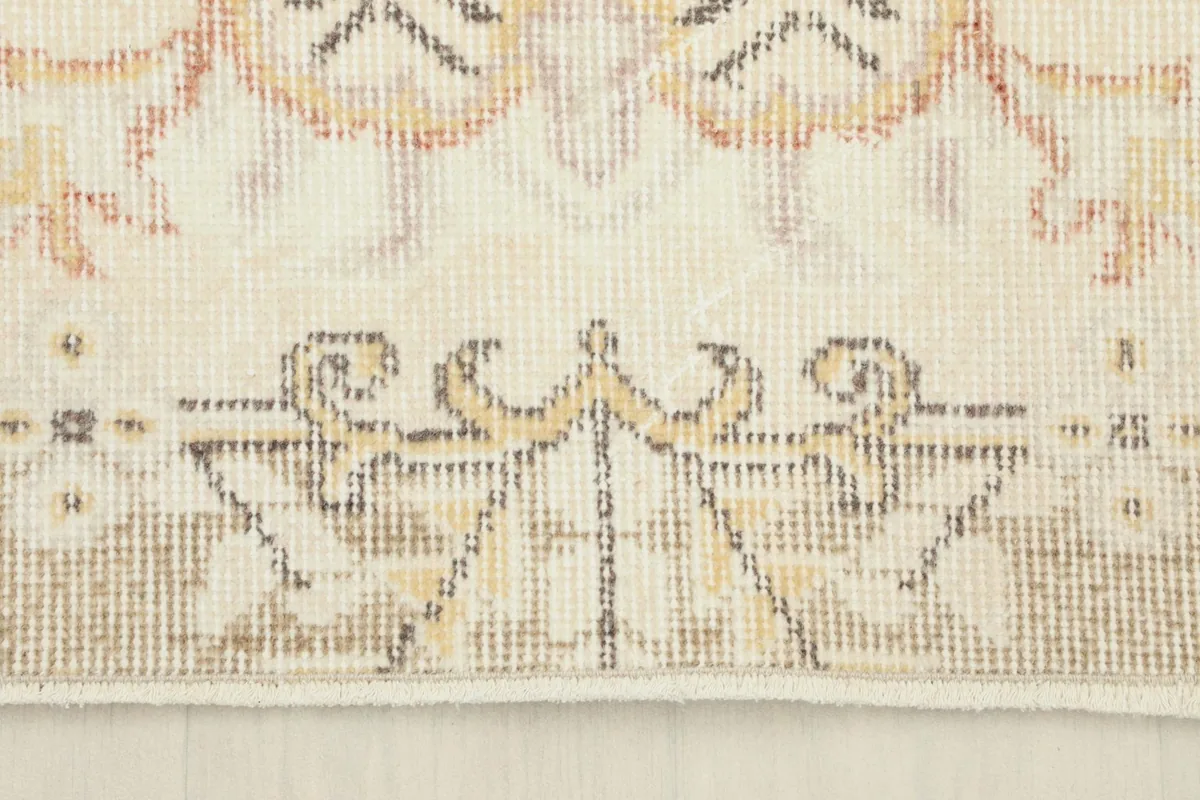 Detailed view of a section of the rug's border, illustrating the intricate patterns and low pile.
