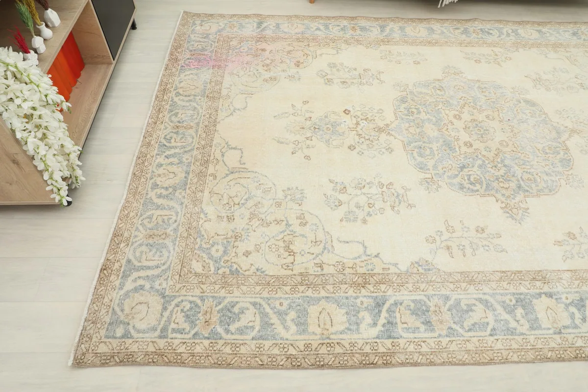 Angled view highlighting the vintage patina and intricate border design of the rug