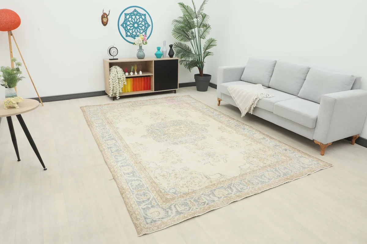 Ivory and blue vintage rug in a living room setting with a light gray sofa