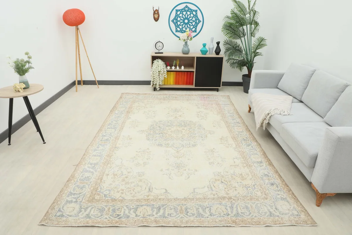 Full room view of the ivory and blue vintage rug, providing a sense of its scale
