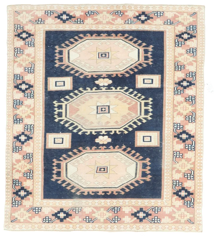 Full top view of the navy and pink geometric vintage Anatolian rug on a white background.