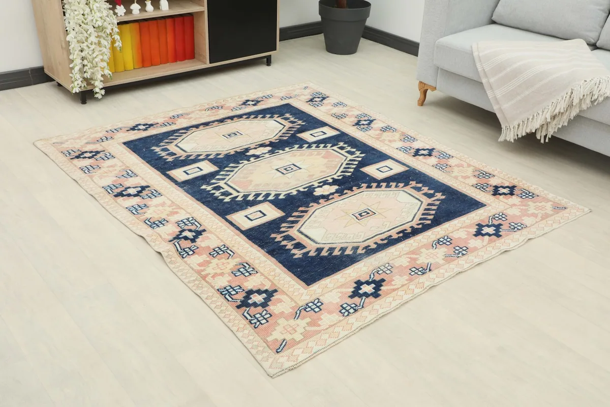 Angle view of the navy and pink rug in a room, showing its placement relative to furniture.