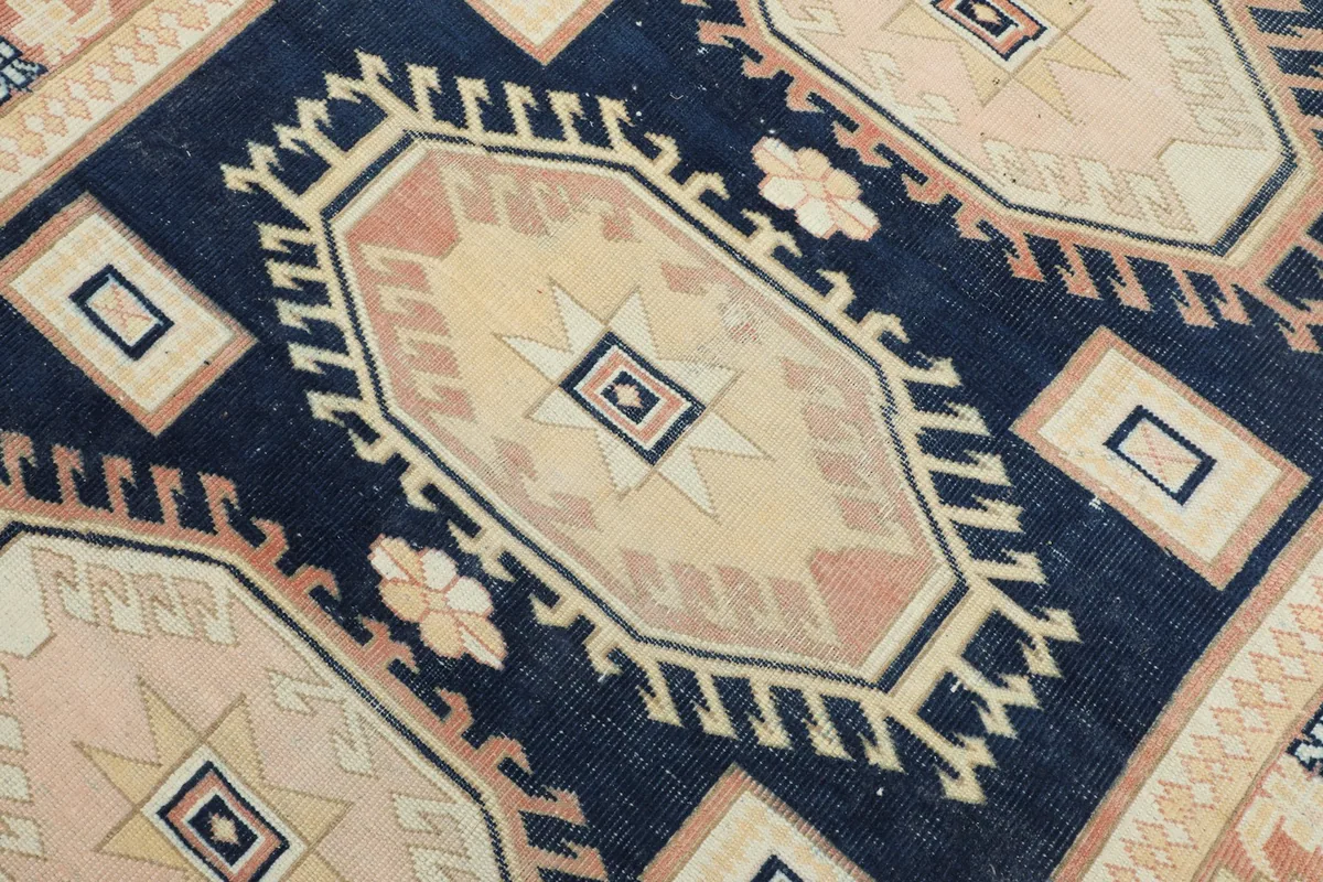 Detailed view of a central geometric medallion and surrounding navy field.