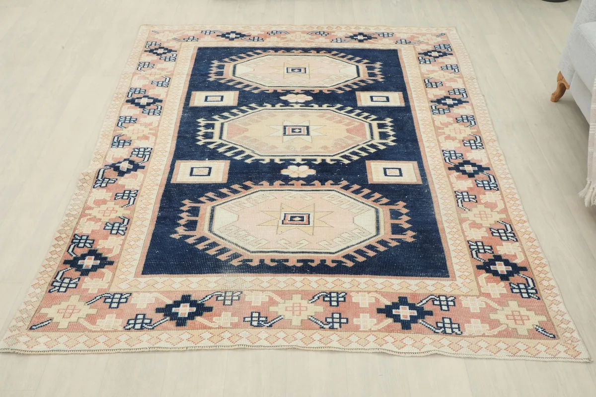 Full overhead view of the navy and pink vintage rug in a room setting.