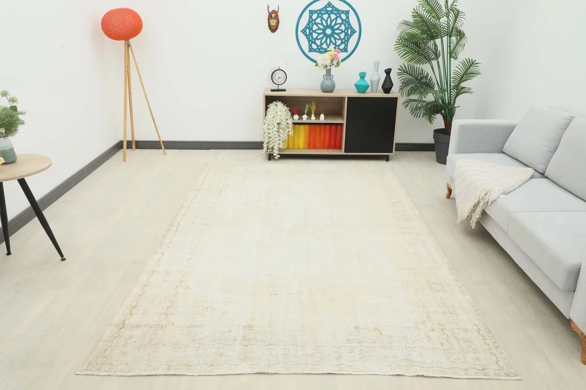 Wide shot of the ivory vintage Anatolian rug filling a modern living room, demonstrating its large size.