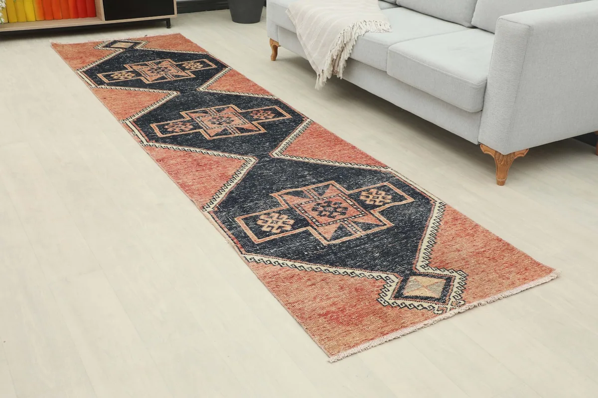 Angle view of the rust and navy geometric runner rug extending down a hallway