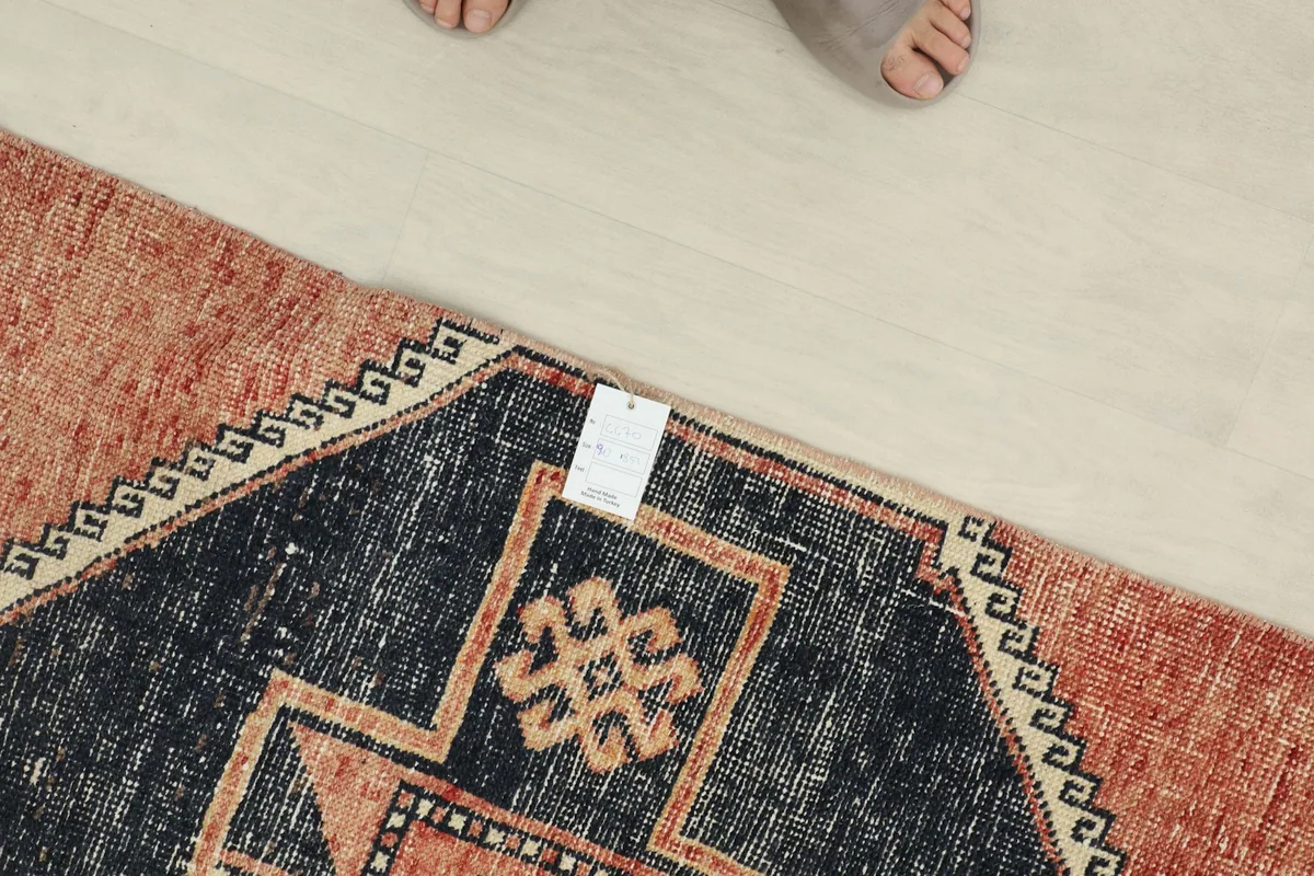 Overhead view of a section of the runner rug, showing the texture and colors with feet nearby