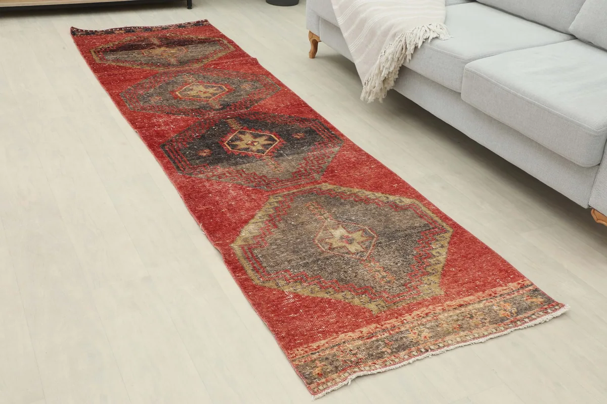 Angled view of the red geometric runner in a room, showing its length and design