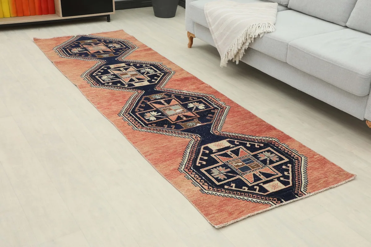 Vintage rust and navy runner rug in a living room setting next to a sofa