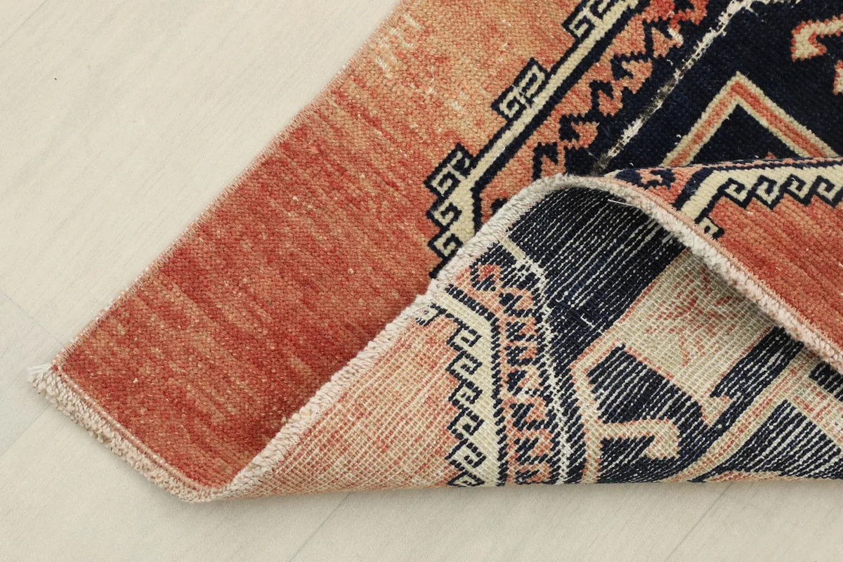 Close-up of the rug's corner, revealing the cotton foundation and hand-knotted construction