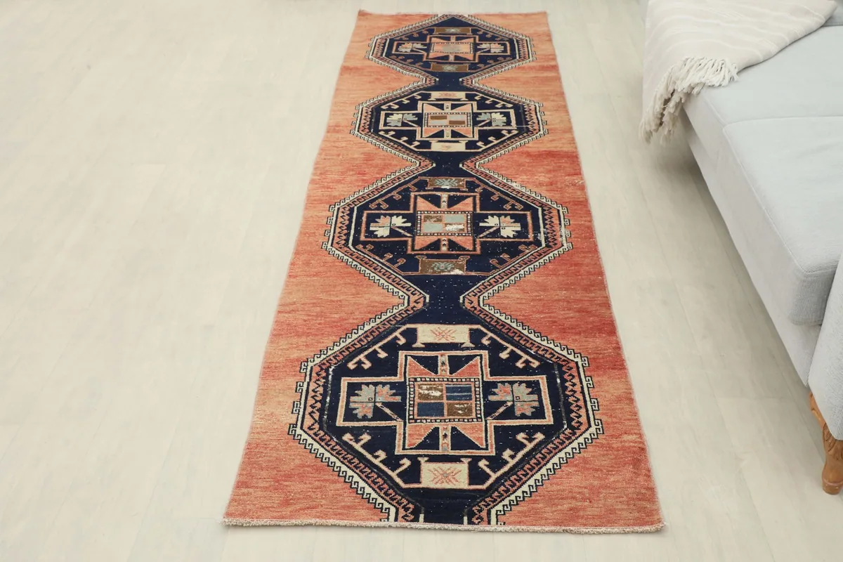 Full overhead view of the rust and navy runner rug in a room setting