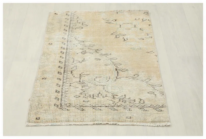 Full overhead view of the beige and charcoal vintage Anatolian rug on a white background.