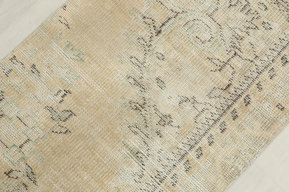 Detailed shot of the rug's surface, revealing the distressed texture and faded patterns.