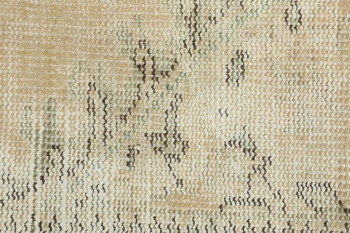 Macro view of the rug's low wool pile and the intricate knotting.