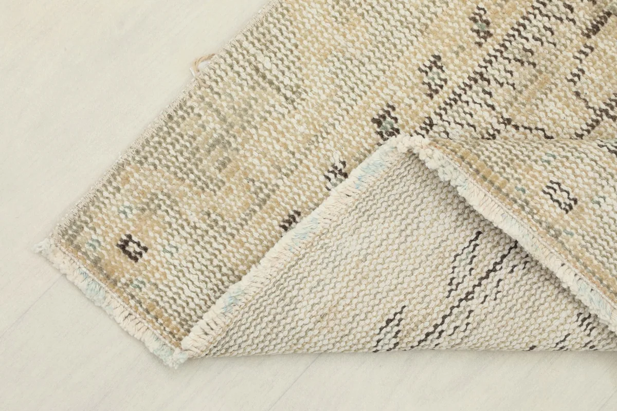 View of the rug's underside, showing the cotton foundation and hand-knotted construction.
