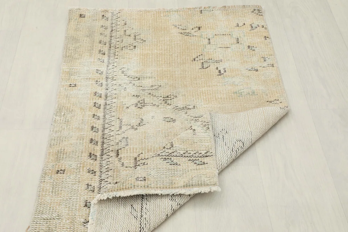 Rug folded to display both the pile side and the cotton foundation.