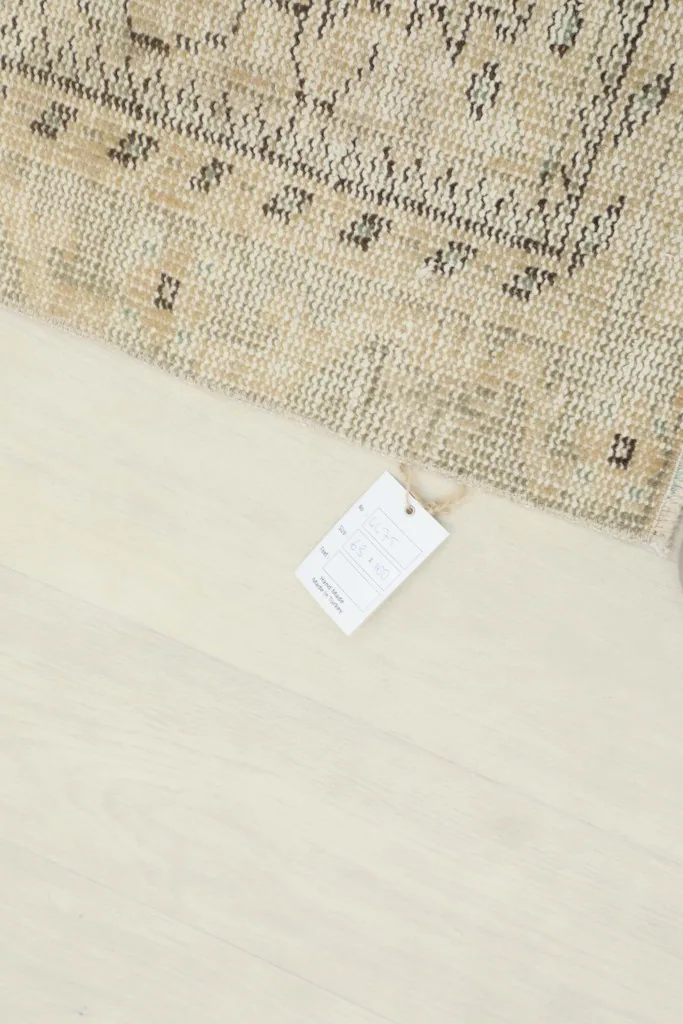 Rug with product tag, indicating its origin and material details.