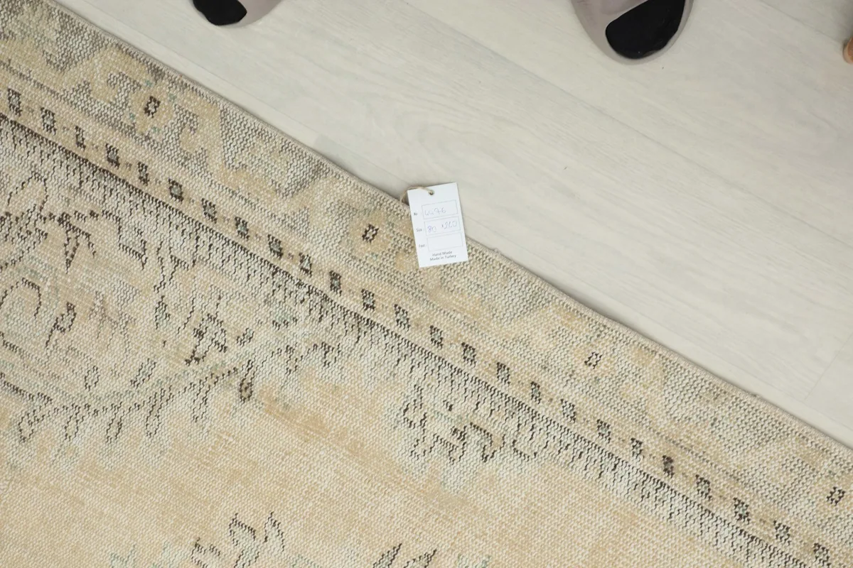 Close-up of the border design and faded patterns on the beige runner