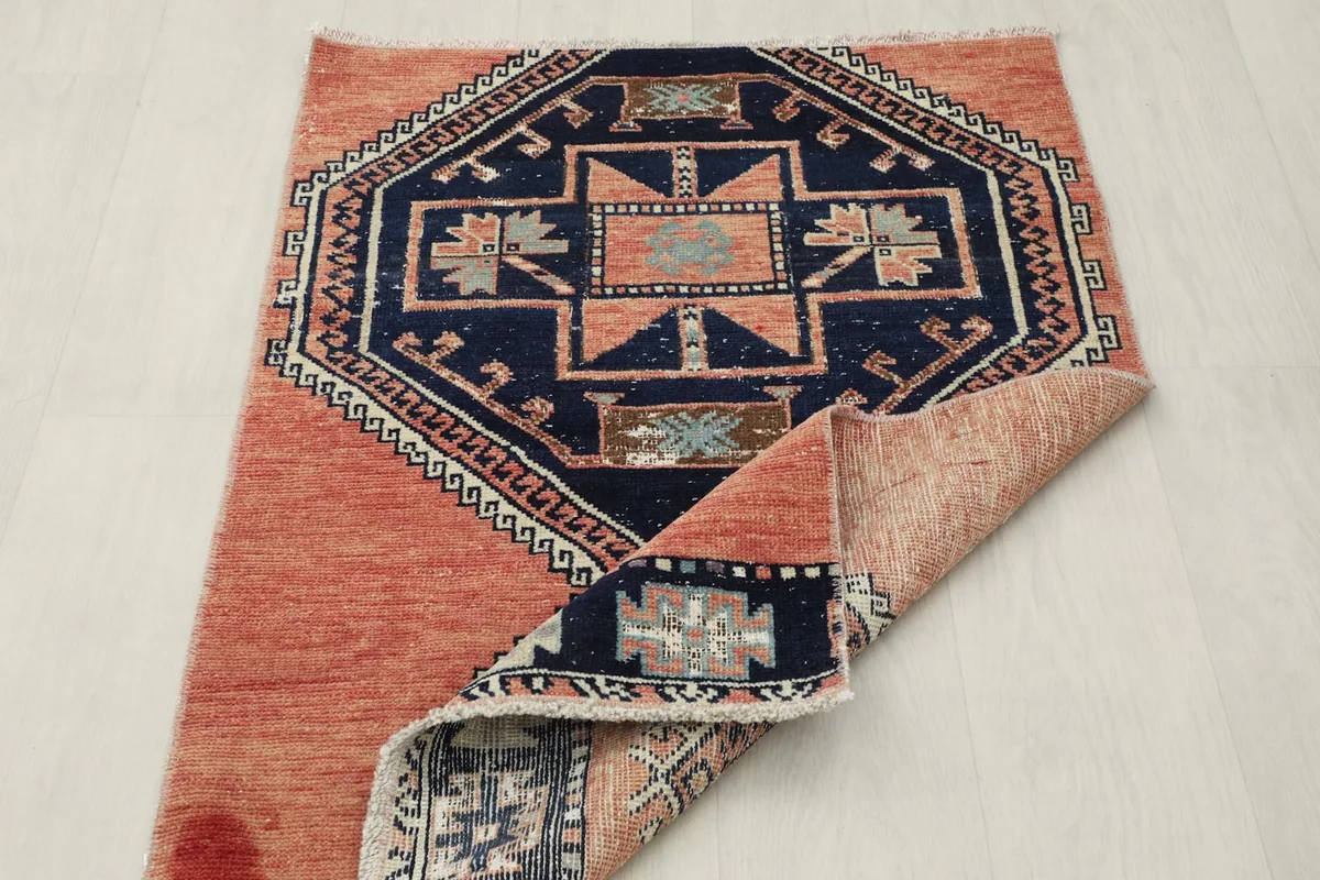 Rug partially folded, displaying the reverse side and the hand-knotted construction