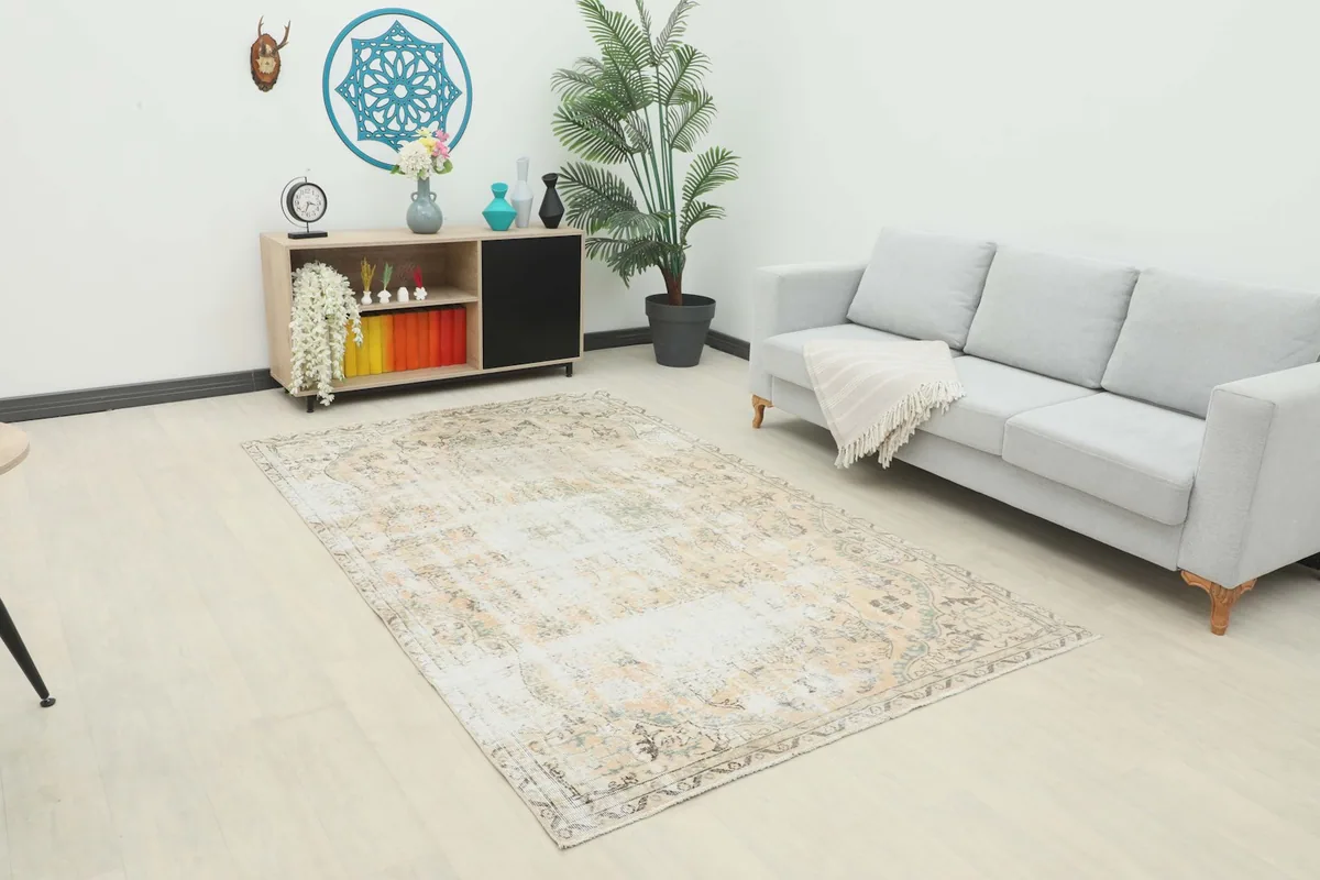 Vintage Anatolian rug displayed in a bright living room setting with a light gray sofa and modern decor.