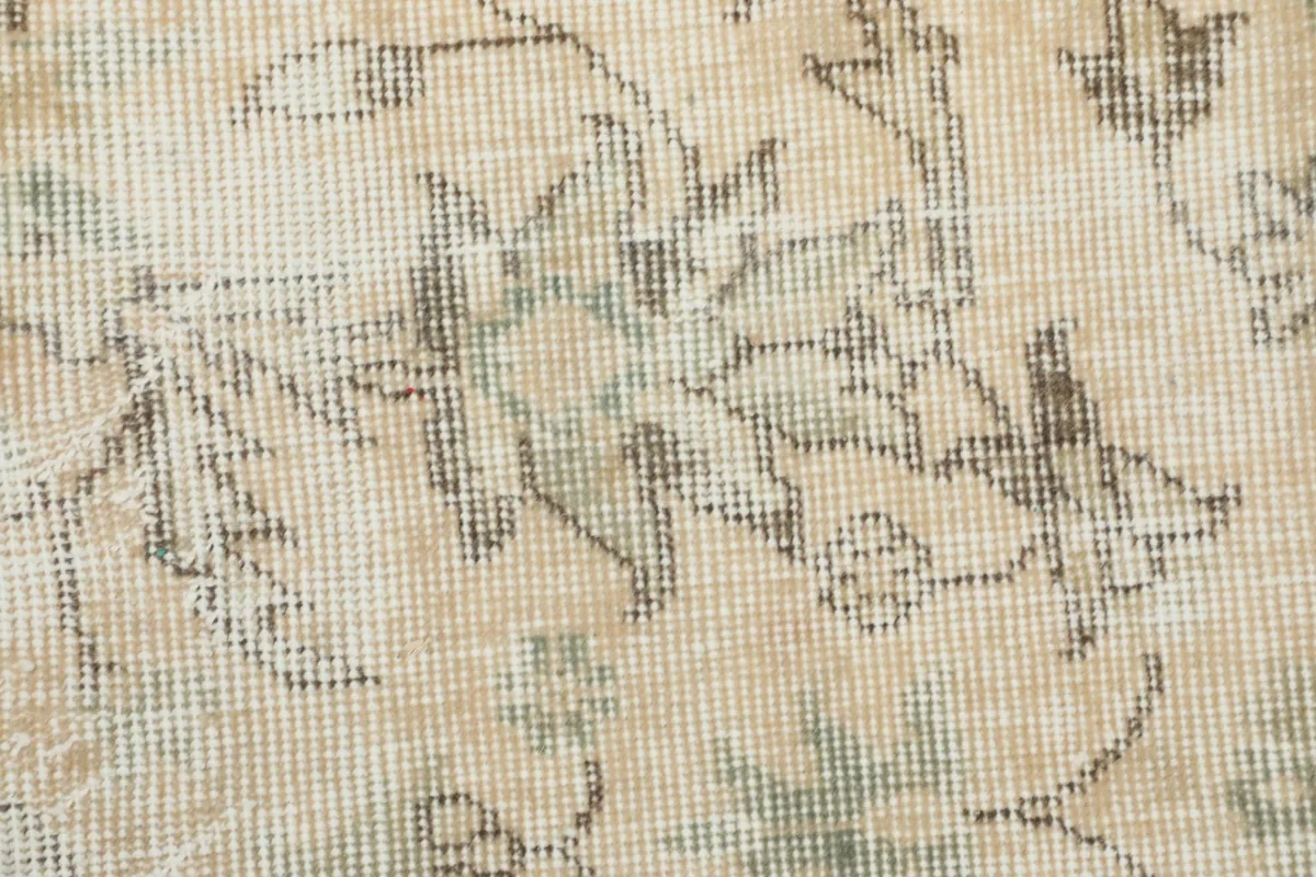 Close-up of the low wool pile, illustrating the hand-knotted construction and the distressed appearance of the fibers.