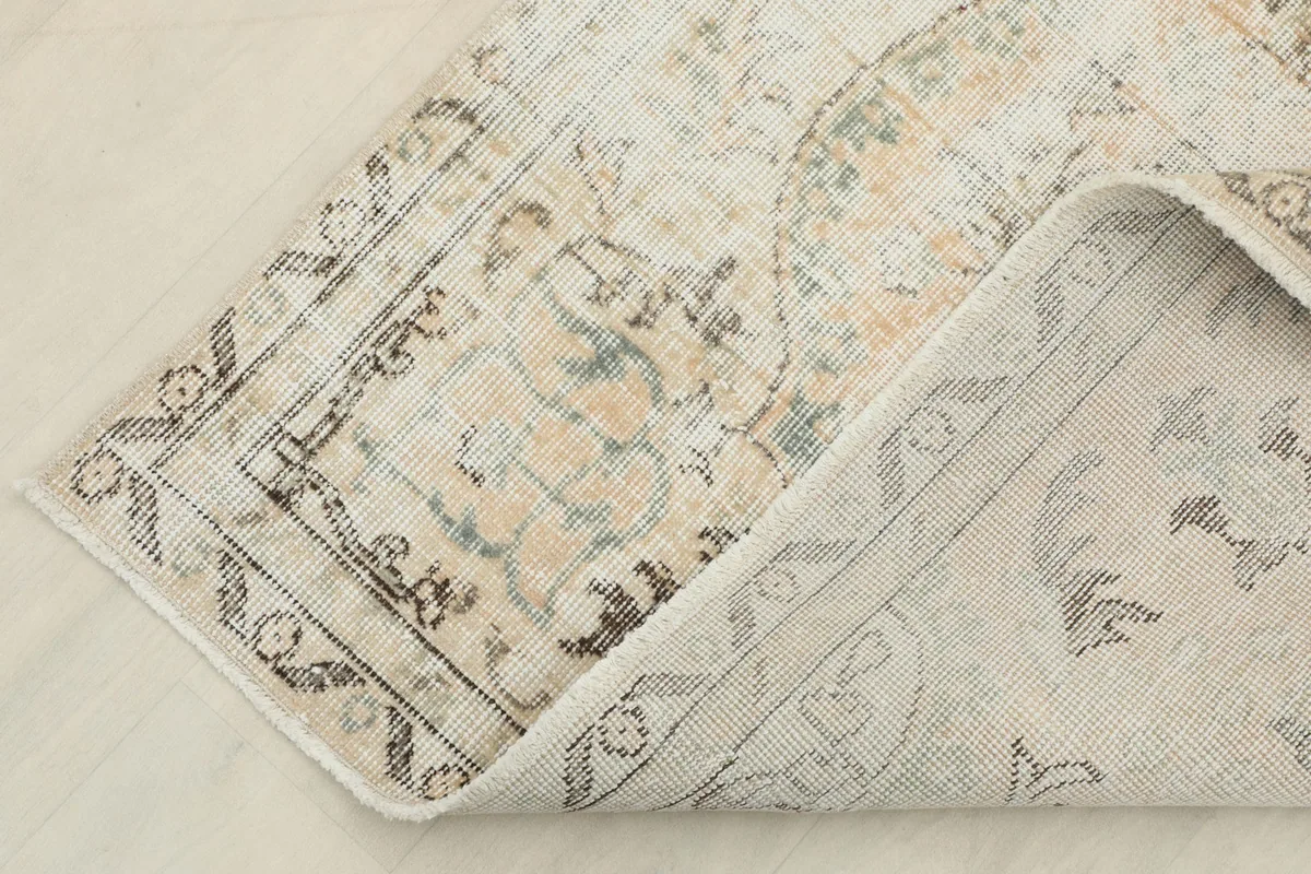 Close-up of the rug's back, showing the consistent knotting and the cotton foundation beneath the wool pile.