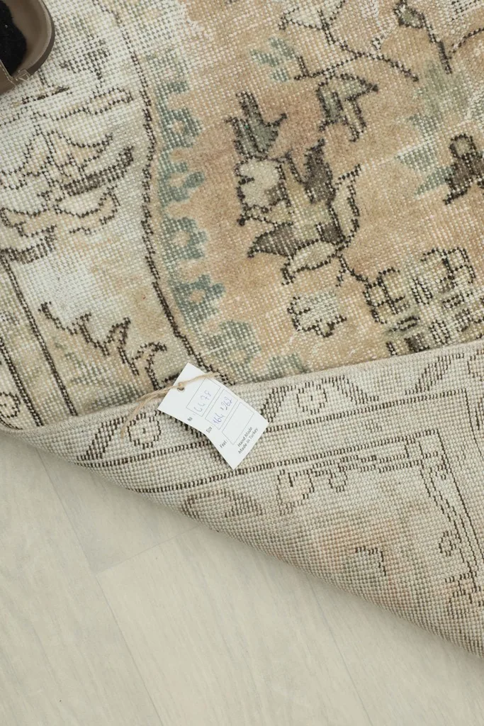 Corner of the rug with a label, indicating its origin and materials, demonstrating its authenticity.