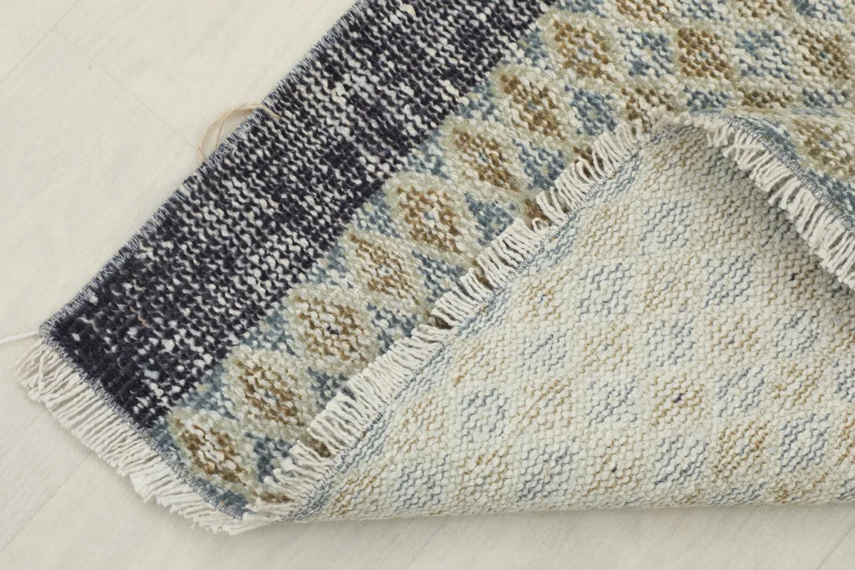 View of the rug's reverse side, showing the cotton foundation and the tightly woven hand-knotted construction.