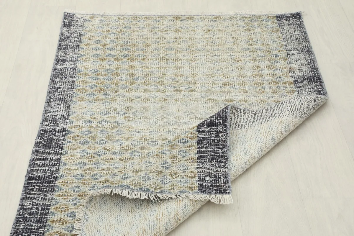 The rug folded back to show the thickness and the durable hand-knotted wool on cotton foundation.